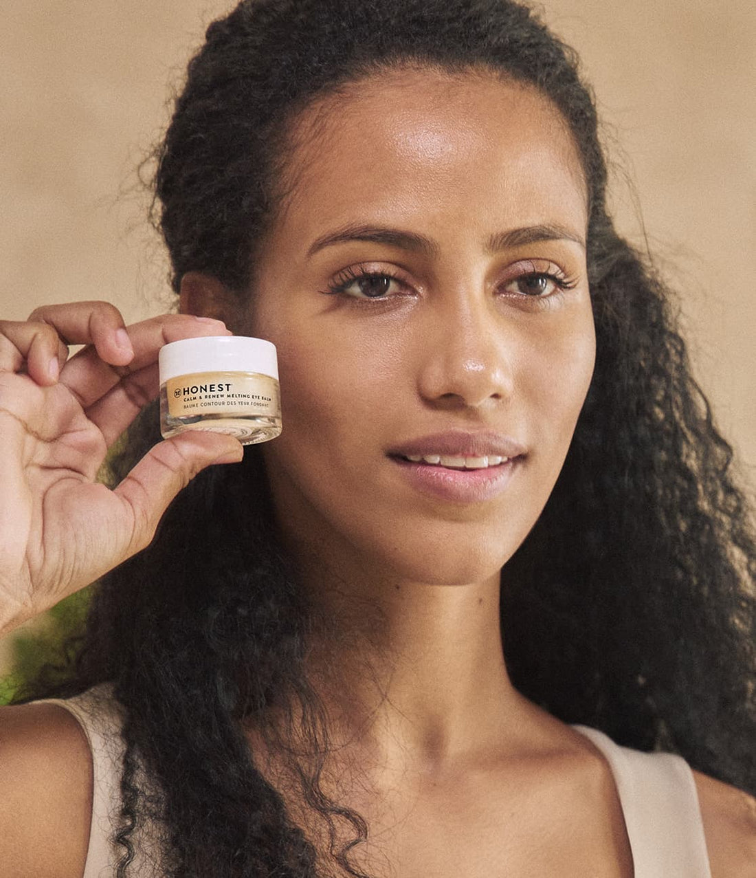 Woman holding Honest Calm & Renew Melting Eye Balm