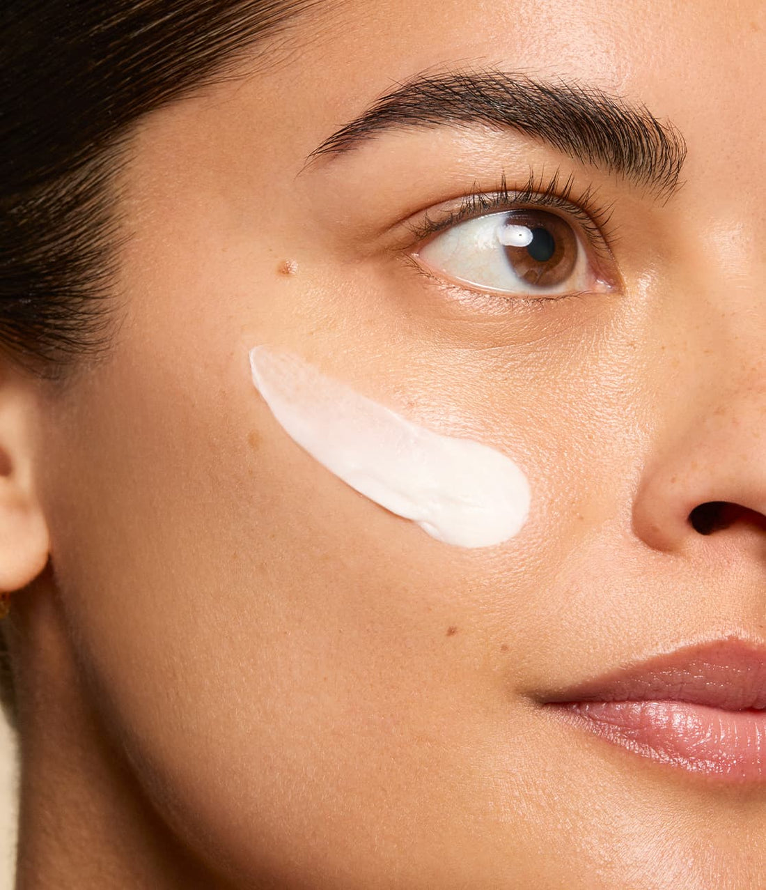 Woman with swatch of moisturizer on cheek