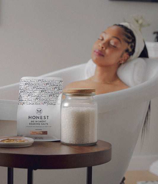 Women in bathtub with Honest Mama bath salts on side table
