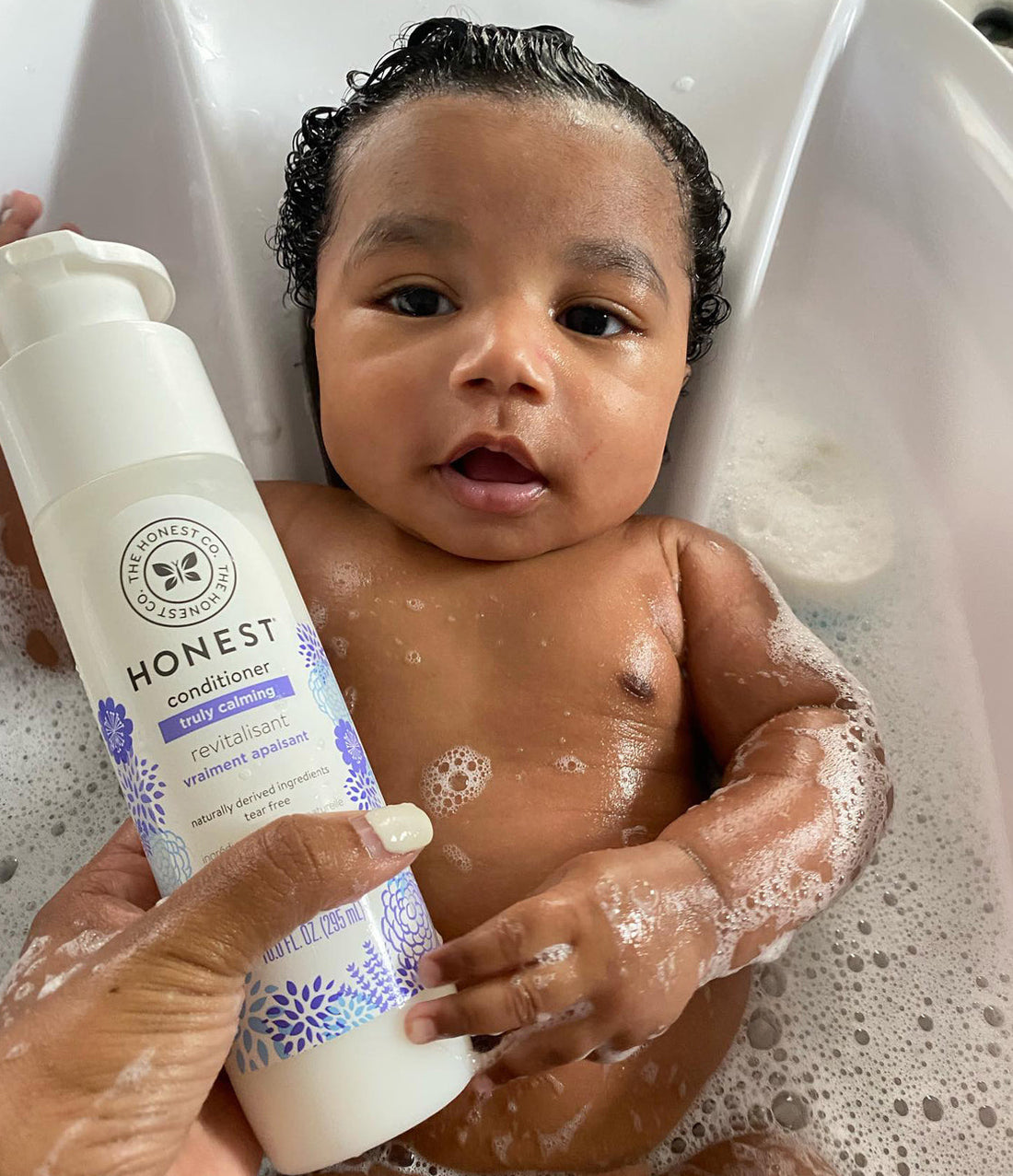Baby in bathtub with lavender conditioner