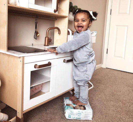girl playing with kitchen sink toy