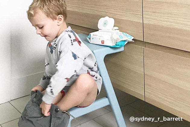 little boy sitting on stool