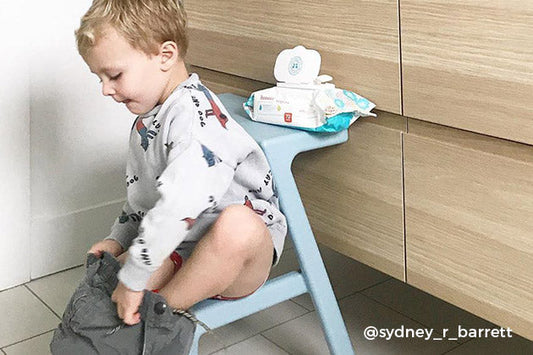 little boy sitting on stool