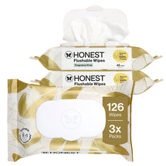 Three packs of Honest Flushable Wipes stacked together on a white background, with one pack showing a white wipe coming out. The packs have a white and gold pattern with a brown badge indicating 126 wipes, 3x packs.
