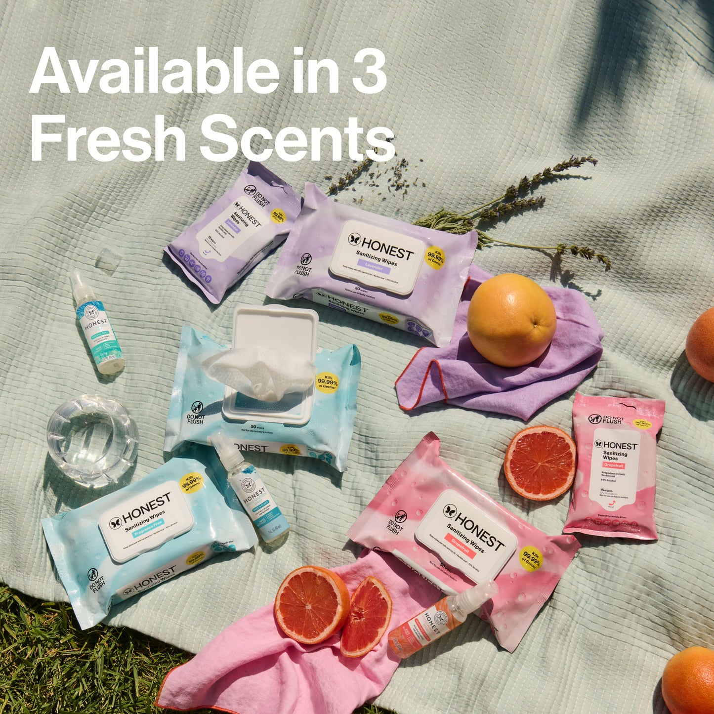 Honest brand products including wipes and bottles on a grassy background with oranges and lavender.